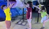 Three children are playfully interacting with a large shark display.