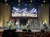 A band is performing on stage under a sign that reads 