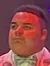 A performer in a sparkly suit holds a microphone on stage with a 