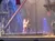 The image depicts a theatrical performance on a pirate-themed stage with performers dressed in costumes, while an audience watches.