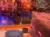 A child is sitting at a table with an empty plate, looking at a stage set with a pirate-themed backdrop.