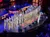A military band is performing on stage at the Grand Ole Opry, with musicians in uniform playing various brass and woodwind instruments.