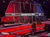 The image shows a vibrant stage setup at the Grand Ole Opry with a piano, microphones, and a backdrop featuring red and black lighting.