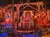 The image depicts an elaborate pirate-themed stage set with ships, skull decorations, and a blue-lit water area, suggesting a theatrical performance arena.