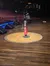 A wooden stage featuring microphones and an 