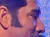 Two performers sing into microphones on stage with a dramatic backdrop featuring a large face.