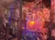 The image shows an indoor pirate-themed stage set with a ship adorned with a skull and octopus motif, surrounded by water and lit with colorful lights.