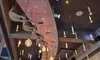 The image shows a modern indoor setting with a creative ceiling design featuring hanging guitars and various pendant lights, alongside a sign for the Grand Ole Opry.
