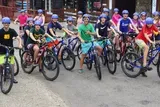 A group of young cyclists wearing helmets are posing for a photo with their mountain bikes.