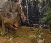 A person in a lab coat and goggles is playfully posing with a large model of a dinosaurs head