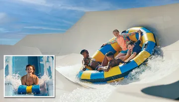 A group of people are enjoying a ride on an inflatable raft down a water slide, with an inset showing a person smiling on a single-person tube.