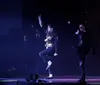 Three performers dressed in Michael Jackson-style outfits are on stage with quotes praising the performance as the greatest MJ tribute act and a true thriller