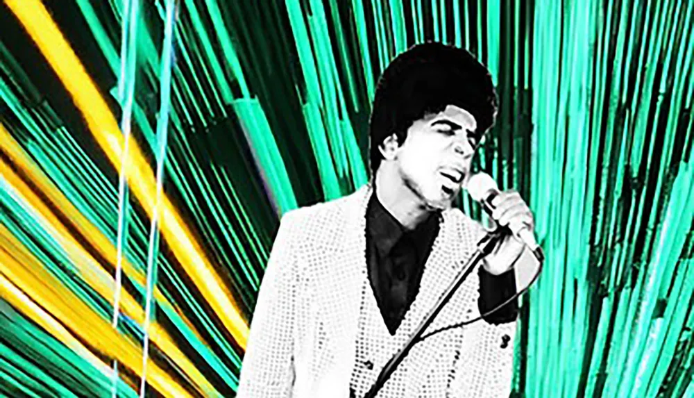 A man in a vintage suit passionately sings into a microphone against a backdrop of vibrant green and yellow geometric lines