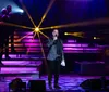 A group of singers performing on stage with a moody blue lighting setup