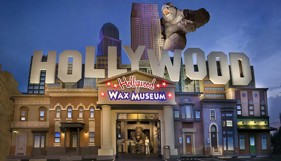 The image depicts the Hollywood Wax Museum, distinguished by its large HOLLYWOOD sign and a wax figure of King Kong climbing the building.