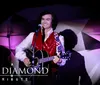 A performer in a jeweled outfit is holding a microphone against a sparkling background with text reading Jerry Presley Elvis Live and Elvis Cousin