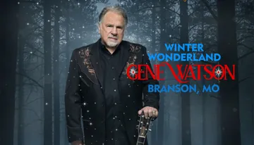 The image features a man in a decorated suit holding a guitar against a forest background, with text saying 