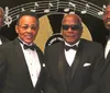Four men in tuxedos stand in front of a backdrop featuring the phrase The Golden Sounds of the Platters