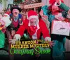 Four people are dressed in colorful and theatrical Christmas-themed costumes expressing exaggerated emotions in what appears to be a festive play or performance