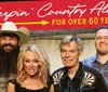Four people are smiling in front of a backdrop with the text Keepin Country Alive for Over 60 Years