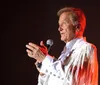 The image is a collage of five photographs showing a smiling man in various outfits including a white shirt a patterned jacket sunglasses and performing on stage with a microphone