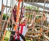 A group of people is enjoying a high ropes adventure course on a sunny day