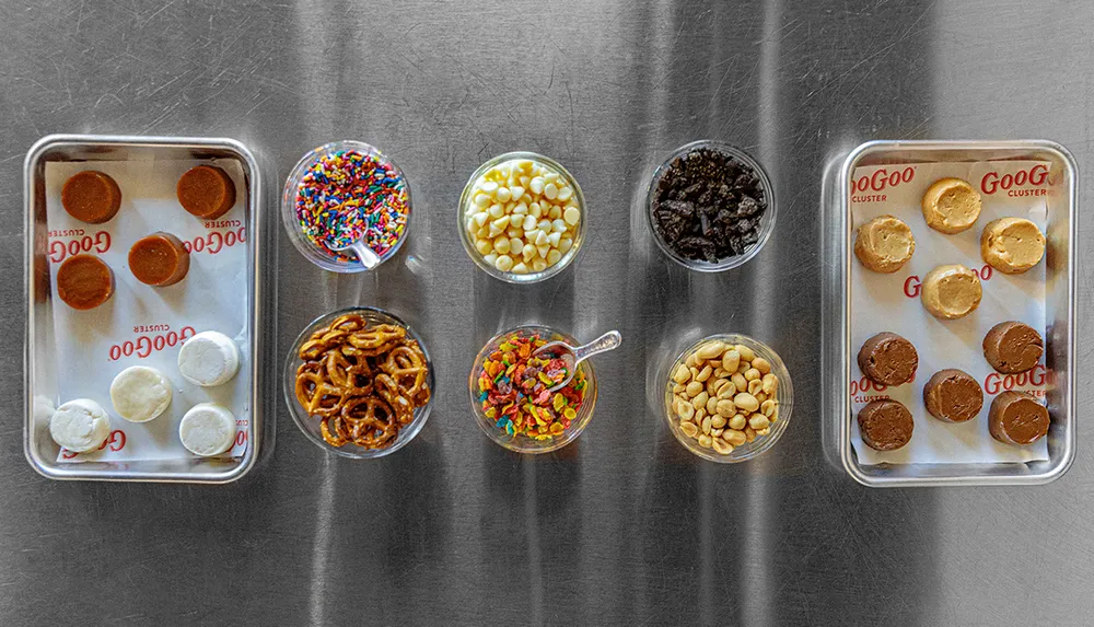 The image displays an assortment of candy-making ingredients and partially completed confections on a stainless steel surface