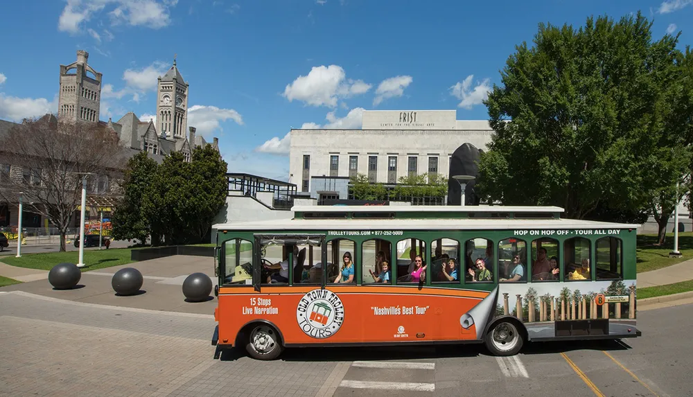 A trolley full of tourists is passing by the Frist Art Museum on a sunny day