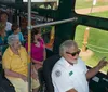 An orange and green trolley bus with the label Old Town Trolley Tours is driving past a row of historic buildings on a sunny day