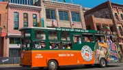 An orange and green trolley bus with the label 