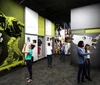 This image depicts visitors engaging with exhibits at a modern museum dedicated to the history and culture of hip hop and rap