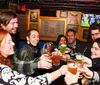 A group of cheerful people are toasting with drinks in a lively bar setting