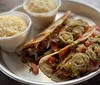 The image showcases a plate with a quesadilla filled with cheese and vegetables topped with fried jalapeo slices accompanied by two cups of what appears to be a side dish like rice or mashed potatoes