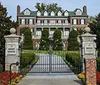 The image features a grand mansion with lush greenery in the background an inset of two people holding plaques and the text See Over 30 Celebrity Homes at the bottom