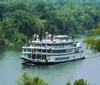 A paddle steamer is cruising along a river flanked by lush greenery