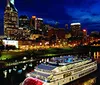 A paddle steamer is cruising along a river flanked by lush greenery