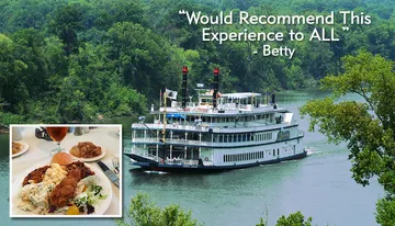 A paddle steamer is cruising along a river flanked by lush greenery.