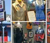 The image shows a display case with various music memorabilia including a decorative guitar photographs clothing a cowboy hat and hand-written notes suggesting a tribute to a musicians career