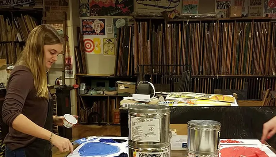 A person is working on an art project amidst a background filled with vinyl records and various art supplies.