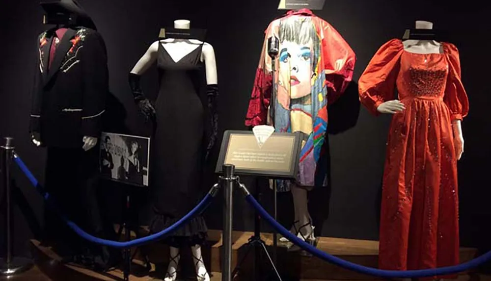 The image shows a collection of different costumes displayed on mannequins potentially part of an exhibition or museum display