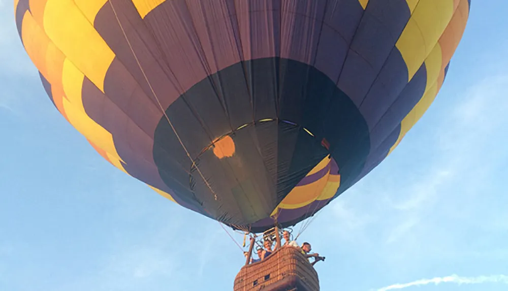 A colorful hot air balloon is floating in the sky with passengers in the basket