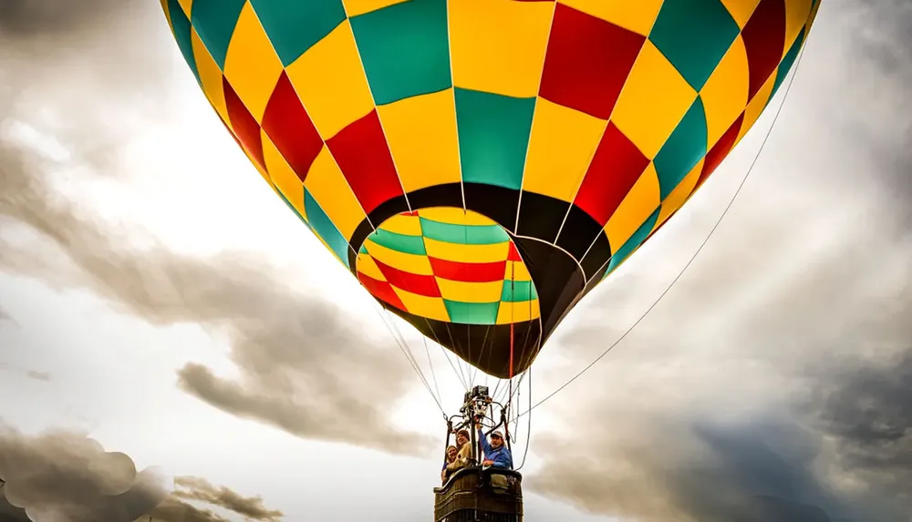 A colorful hot air balloon is ascending into a cloudy sky with people in its basket