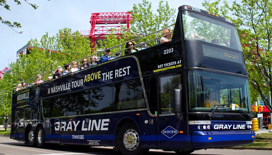 Passengers enjoy the view from the open-top deck of a Gray Line double-decker sightseeing tour bus in Nashville.