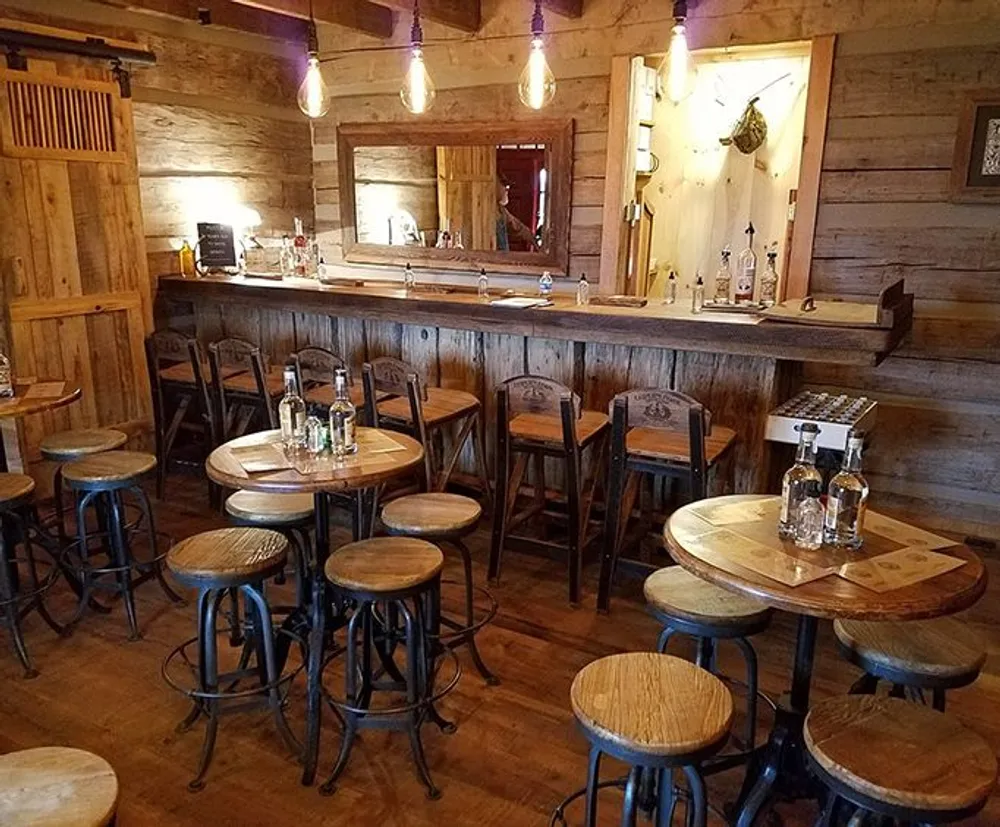 The image shows a cozy wooden interior of a bar with stools tables and a counter but no visible patrons