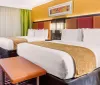 The image shows a colorful hotel room with two beds bright walls and modern decor