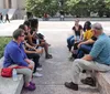 A group of people is standing on a sidewalk reading a historical marker titled Nashville Sit-Ins in an urban setting