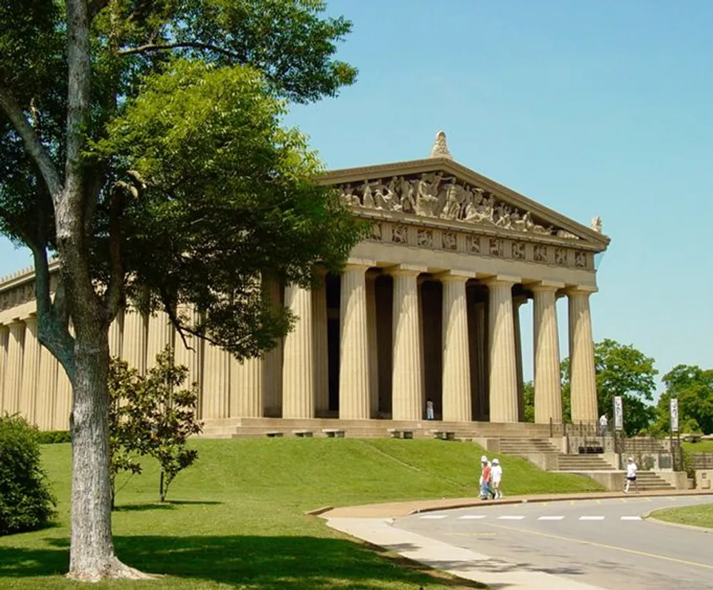 This image depicts the Parthenon replica in Nashville Tennessee on a sunny day with people walking in the foreground