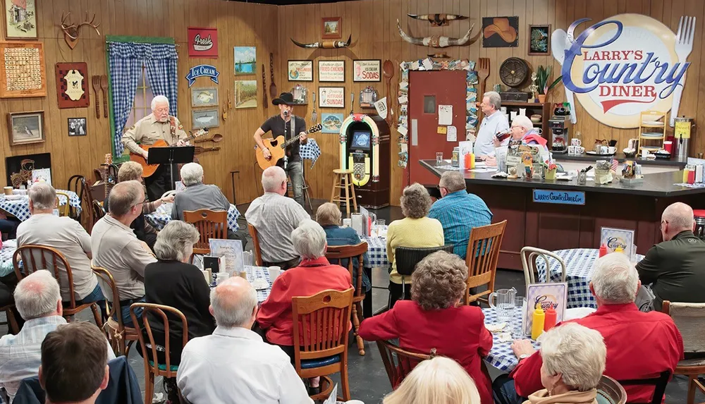 A group of people is enjoying a live musical performance inside a cozy rustic-themed diner adorned with various decorations on the walls