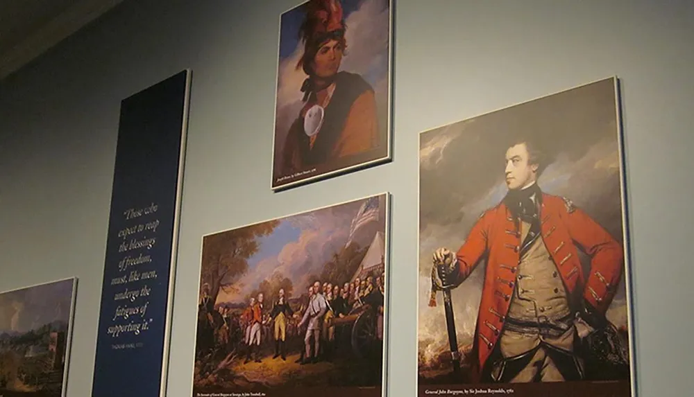 The image shows a gallery wall with four framed paintings depicting historical figures and scenes accompanied by a quote on the wall to the left