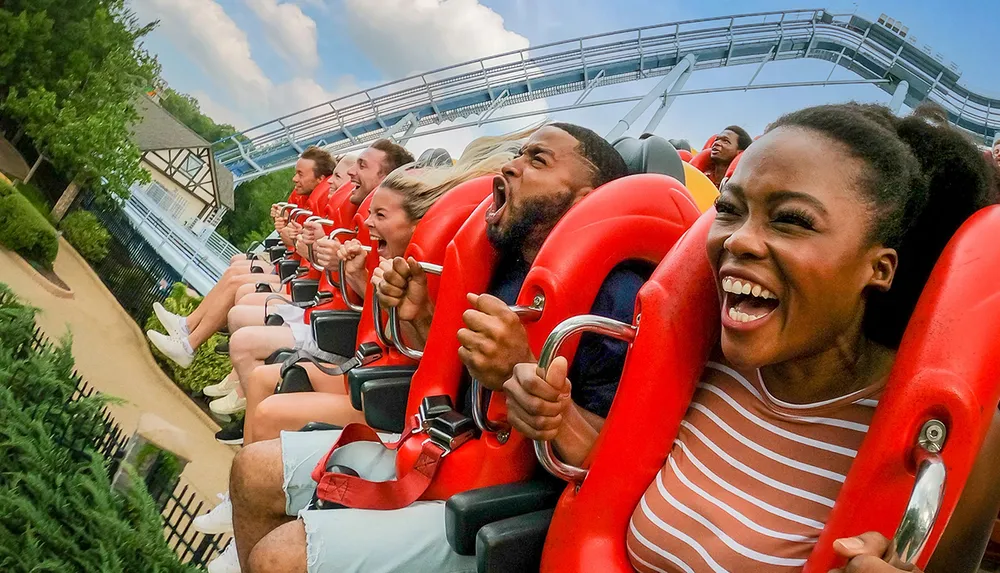 A group of people are enjoying a thrilling ride on a roller coaster displaying a mix of excitement and exhilaration